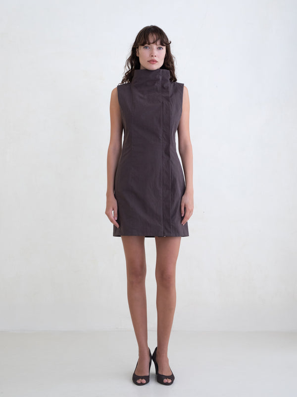 Woman wearing a brown sleeveless mini dress on a white background 