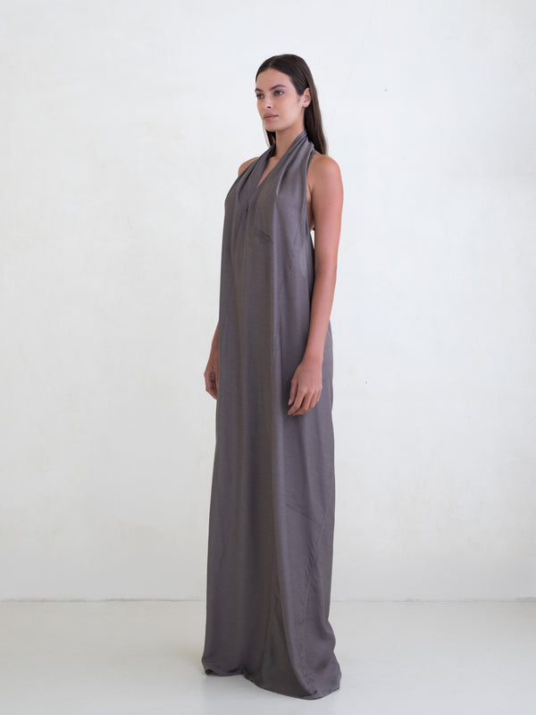 Woman wearing a taupe sleeveless maxi dress on a white background 
